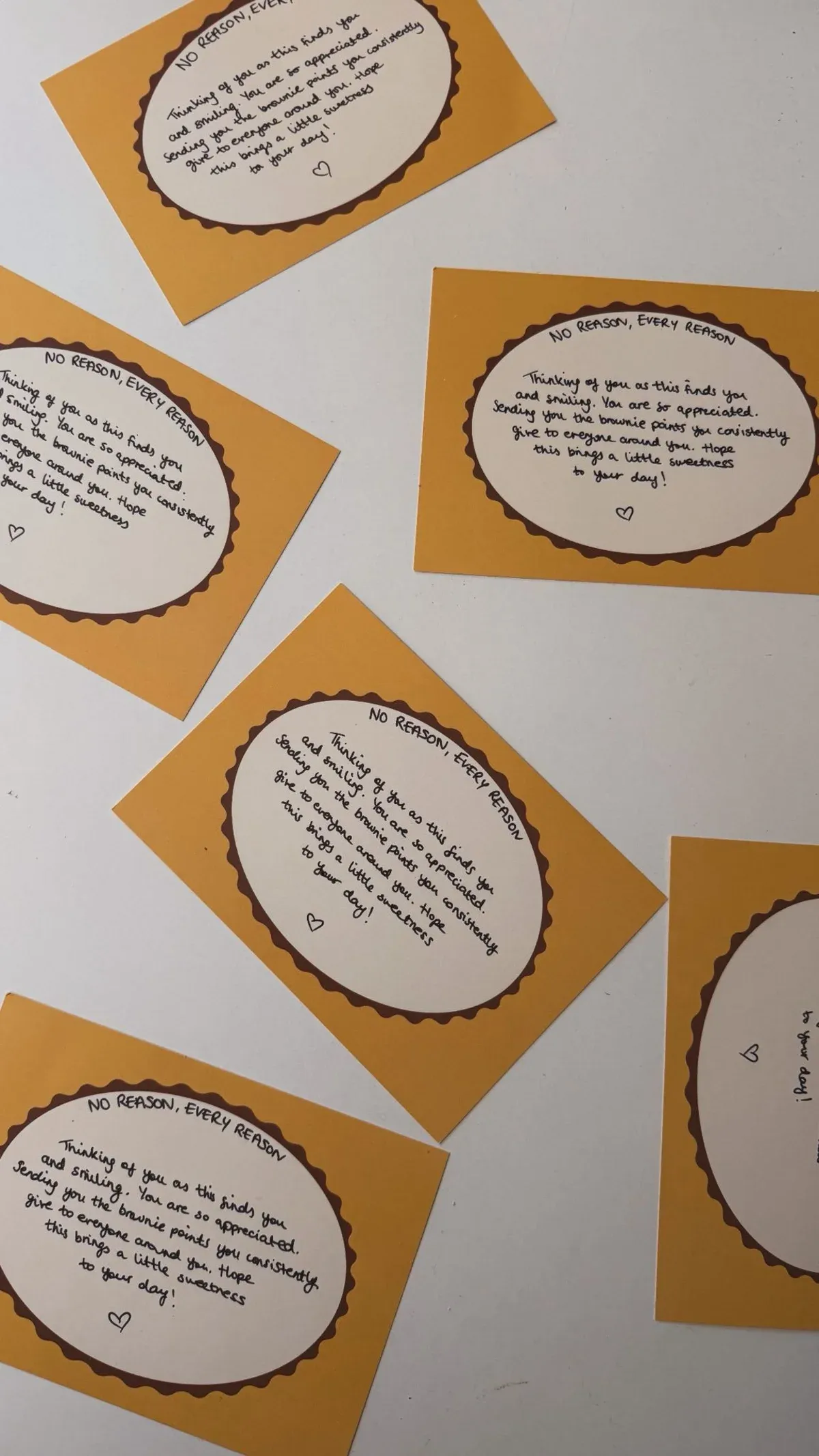 Six yellow message cards spread on a white table, each handwritten with the same ready-written message.